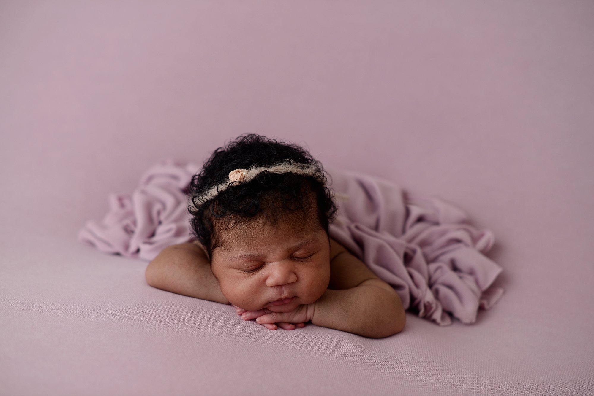 Queens Photography Studio Newborn Baby Girl on a purple backdrop with purple blanket