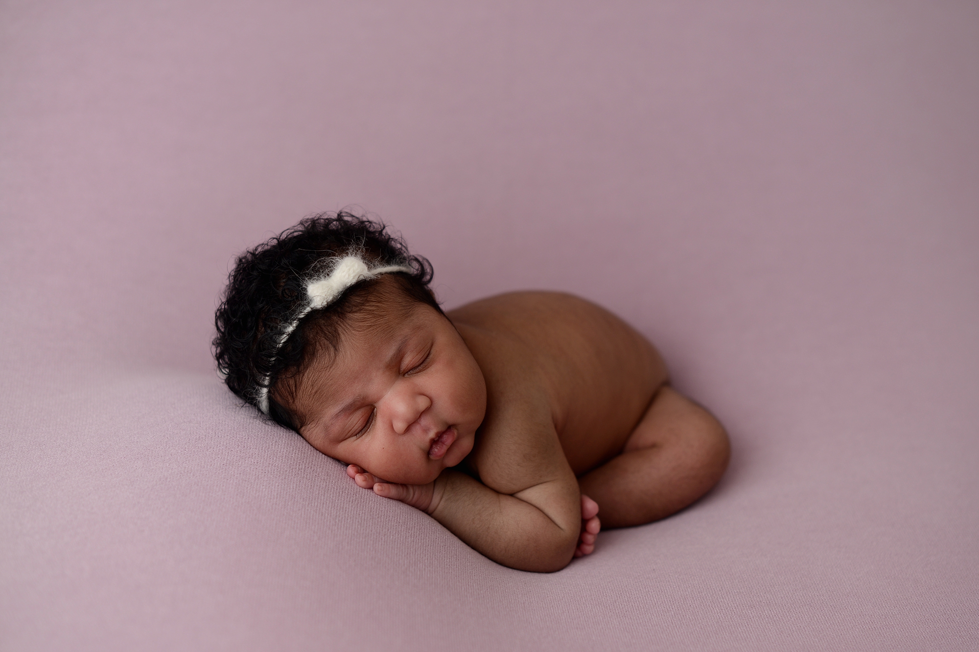 Newborn Baby Girl on a purple backdrop at Brilianna Photography Queens Photography Studio in New York