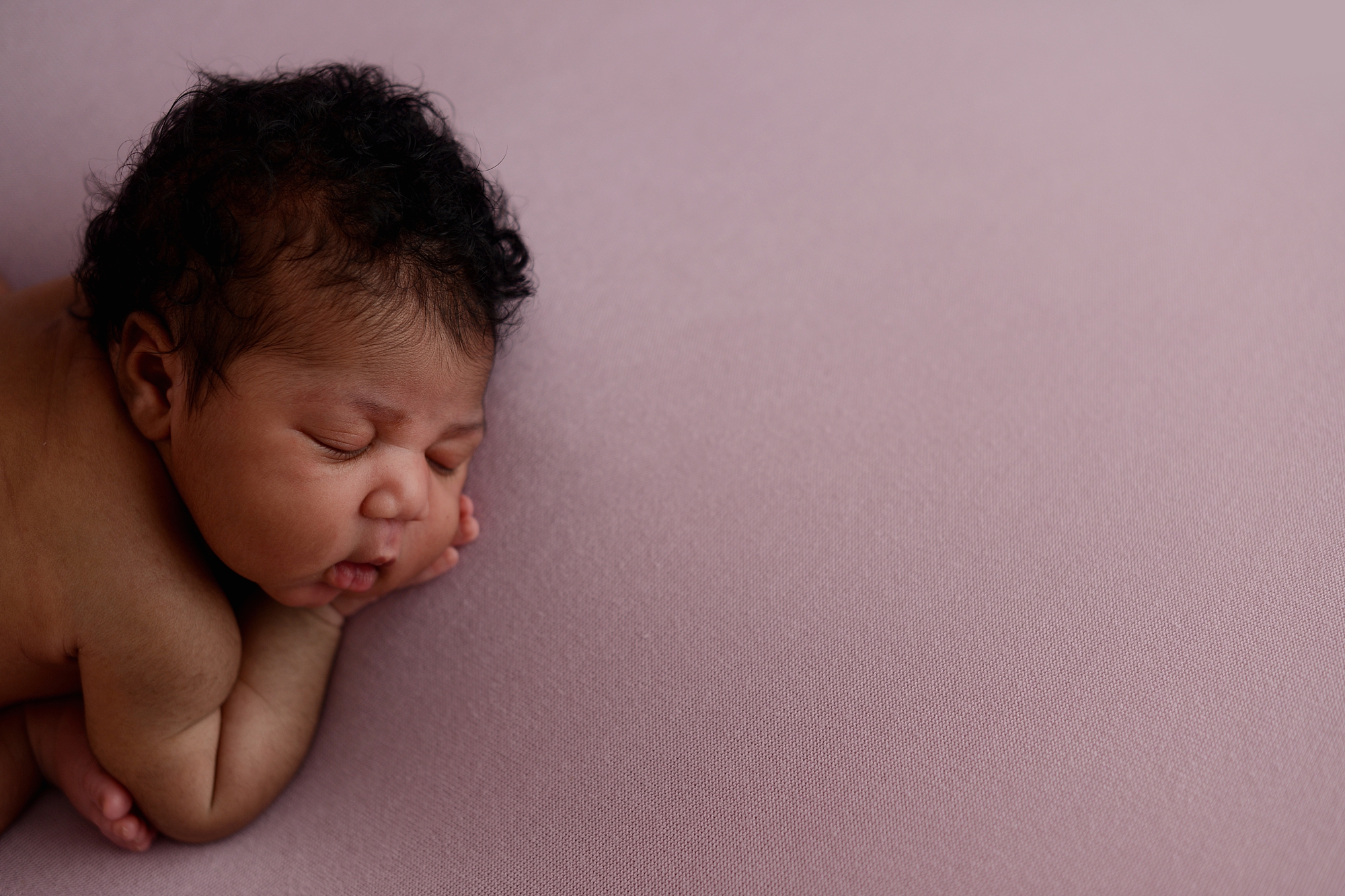 Sleepy newborn girl on a purple backdrop at Brilianna Photography Queens Photography Studio in New York