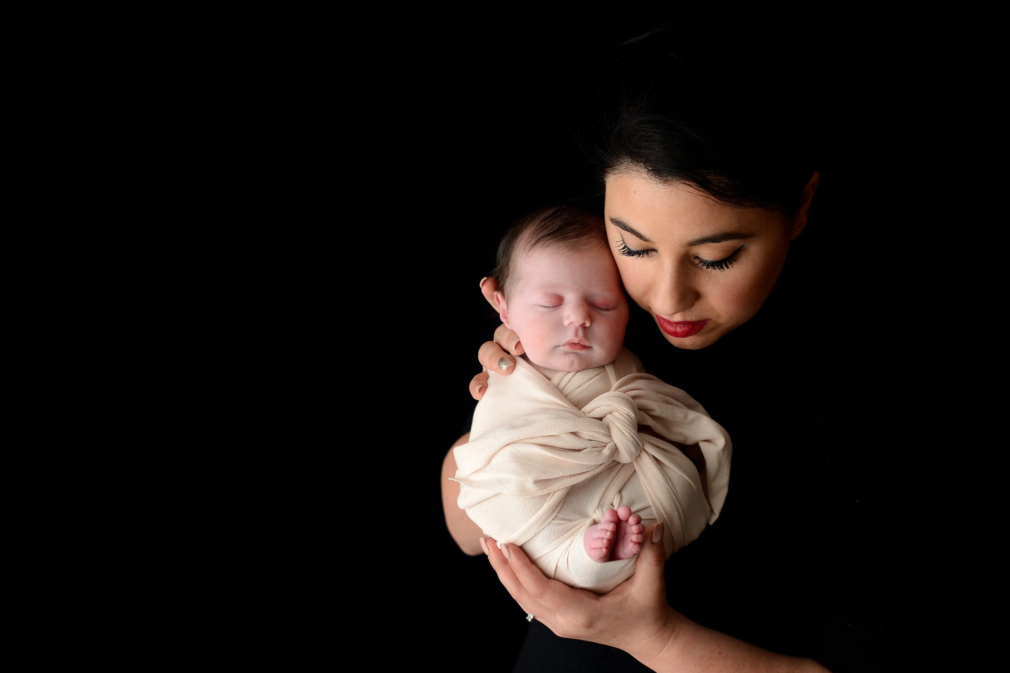 Mother holding newborn baby girl at Queens Portrait Studio
