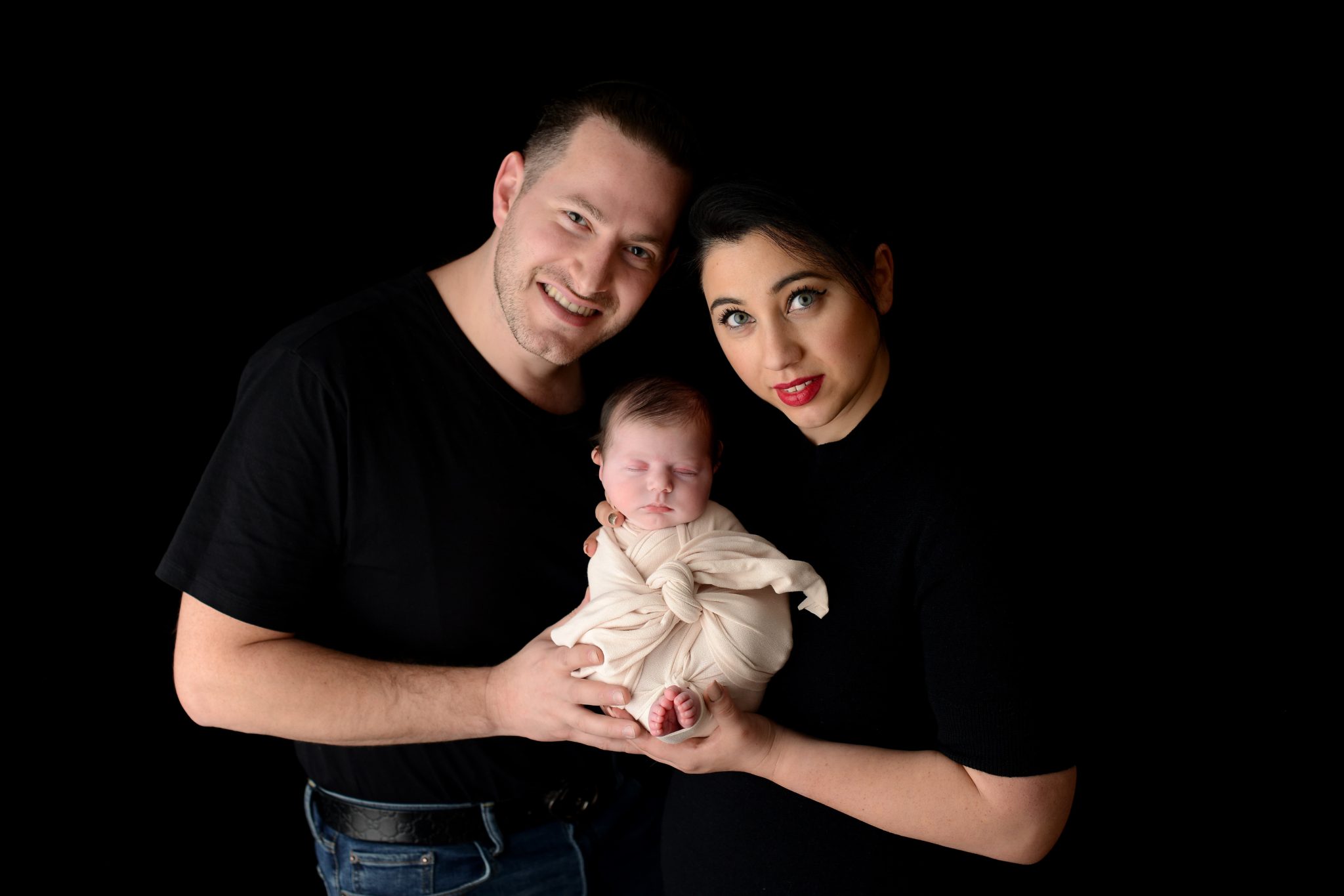 Parents holding newborn baby girl at Queens Portrait Studio