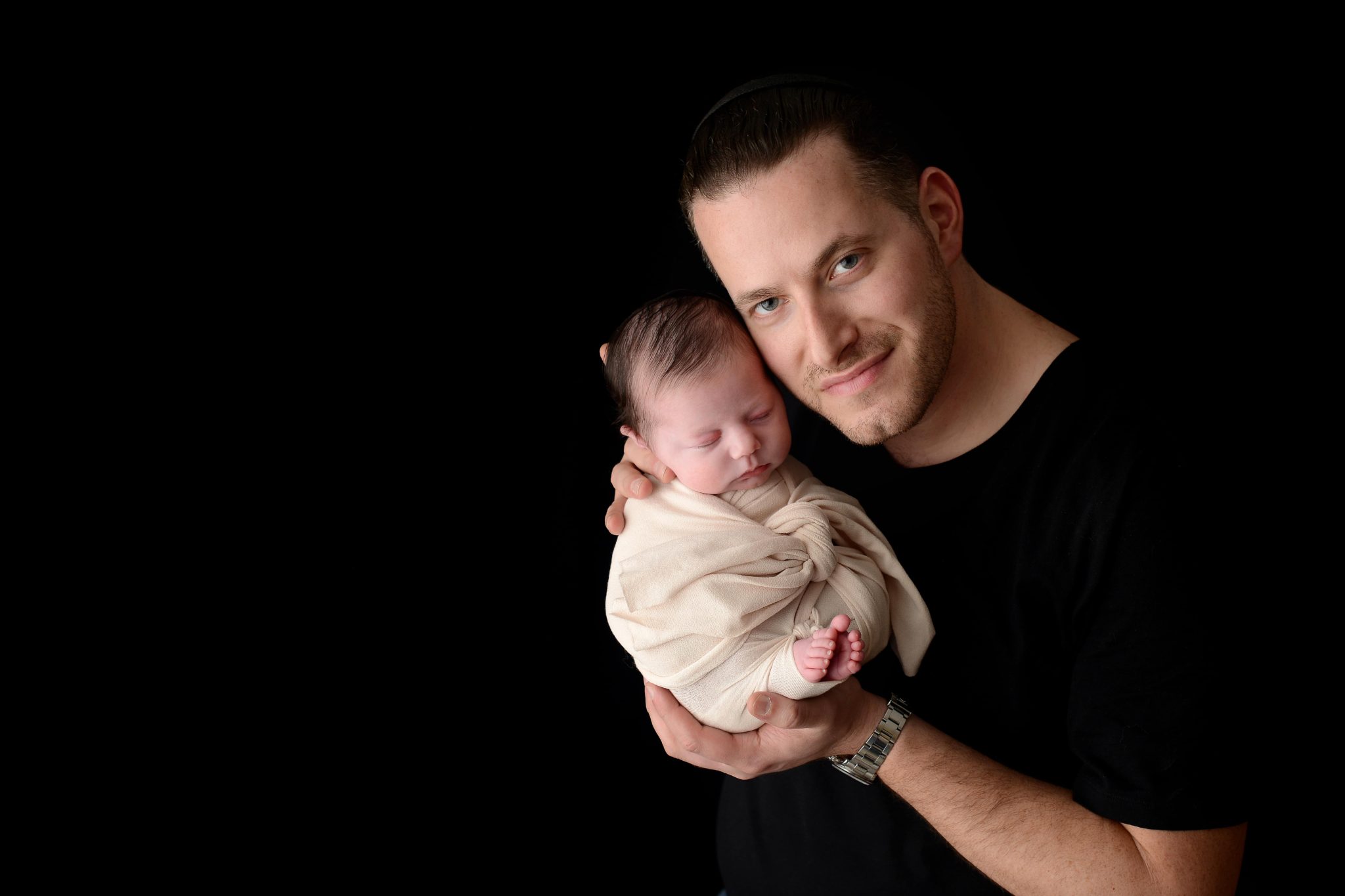 Father holding newborn baby girl at Queens Portrait Studio