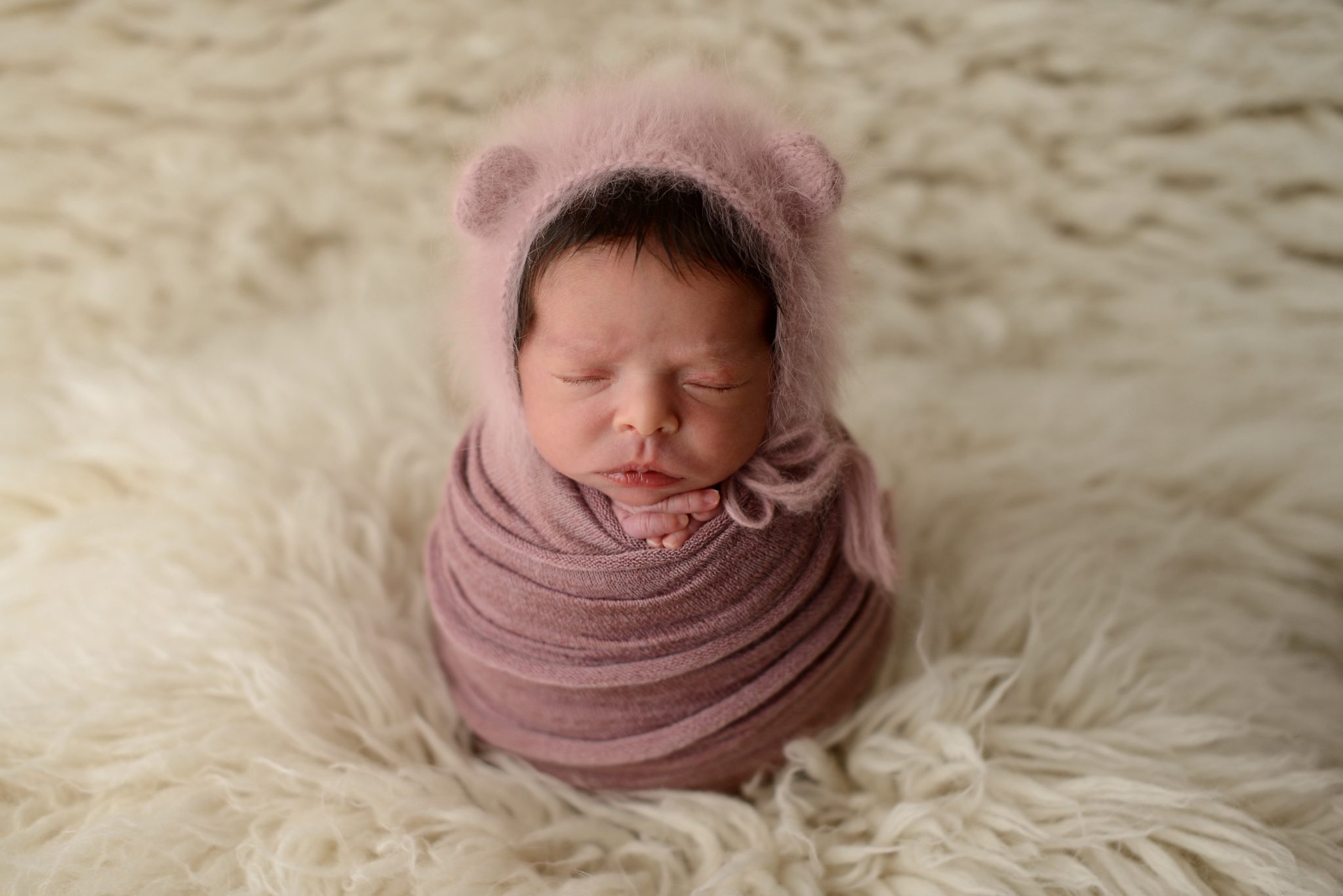 Queens newborn studio portrait of baby girl on cream backdrop