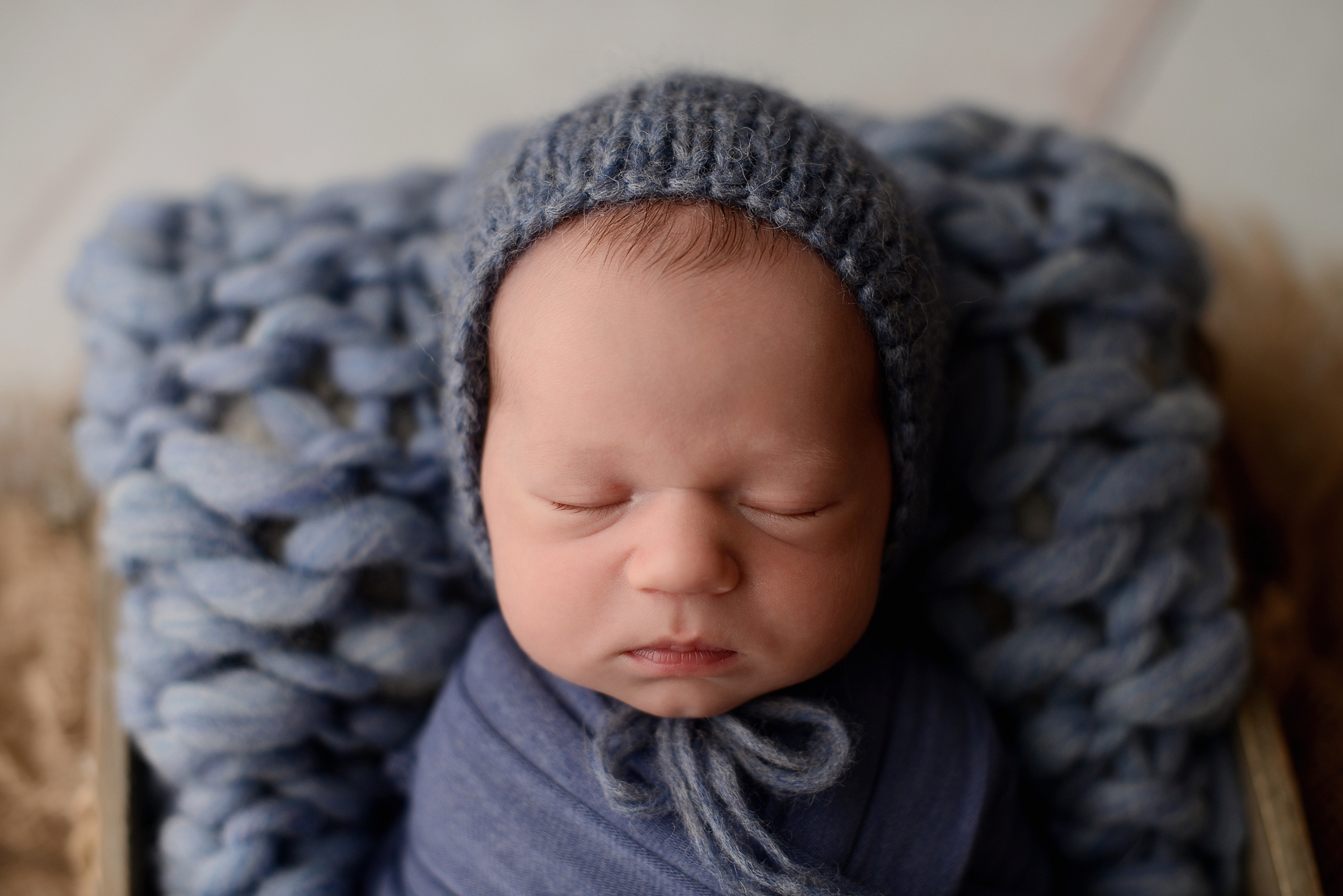Newborn baby boy in blue box in Queens Photography Studio